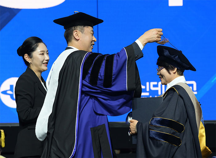 고성환 방송대 총장이 직접 졸업생의 학사모 술을 옮겨주고 있다.