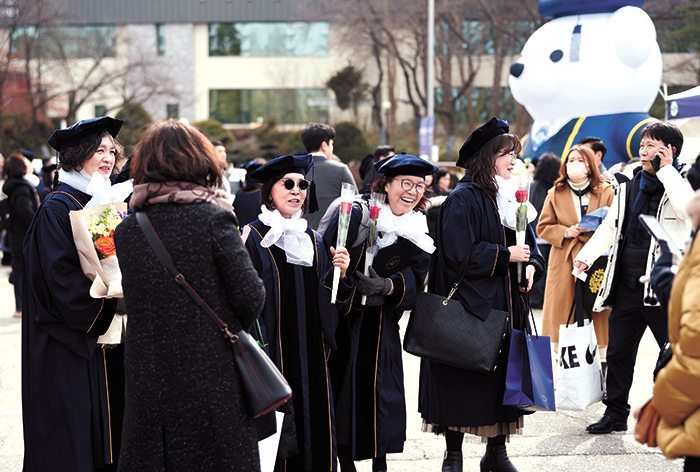 포토존에서 기념사진을 촬영하기 위해 줄을 선 졸업생들이 환하게 웃고 있다.