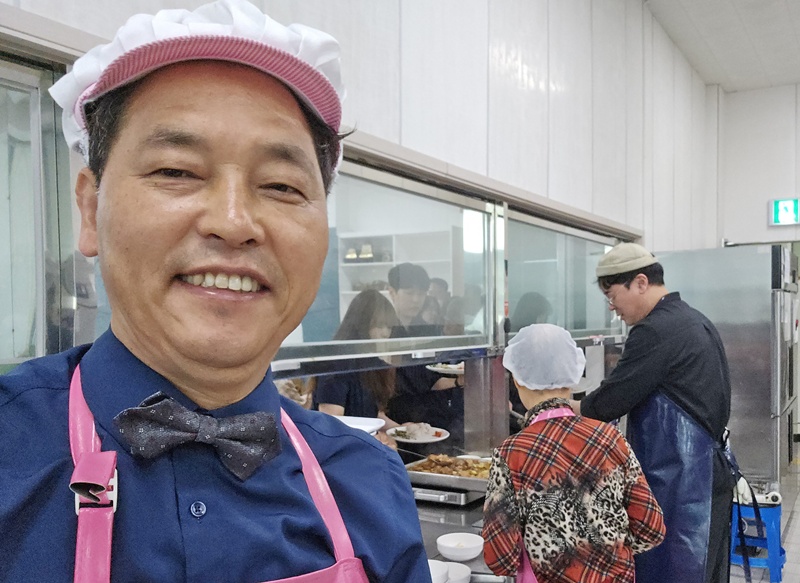 울산에서 25년째 봉사 활동을 펼치고 있는 김희덕 학우(미디어영상)가 장애인복지회관에서 급식 봉사를 하던 중 포즈를 취했다.